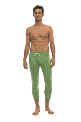 Mens 4/5 zipper pocket capri yoga pants in solid bamboo green with white drawstring waistband and side pockets