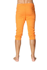 Mens cuffed yoga pants in solid sun orange with a relaxed fit elastic waistband and bright capri length