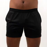 Black mesh back short with smooth stretchy fabric and elastic waistband shown from the back side