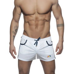 White mesh athletic shorts with navy blue drawstring and trim featuring a colorful logo on the lower right leg