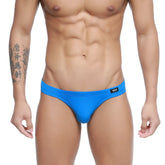 Bright blue form-fitting swim trunks with a black logo tag on the waistband metroMalewear azul real bikini 5103-82