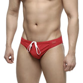Red swim trunks by MetroMaleWear featuring a white drawstring and rectangular brand tag on the waistband