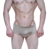 Shiny metallic gold MetroMaleWear Charlie swim briefs with subtle texture and small red brand tag on waistband