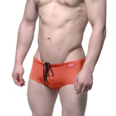 Orange MetroMaleWear Charlie swim briefs with black drawstring and small pink brand tag for casual beachwear