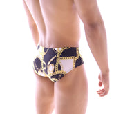 MetroMalewear classic swim brief in black and white with bold gold chain pattern for stylish beachwear