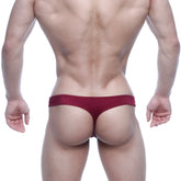 A sleek deep red MetroMaleWear Eureka Thong made of smooth fabric with a minimalist design showing the back side