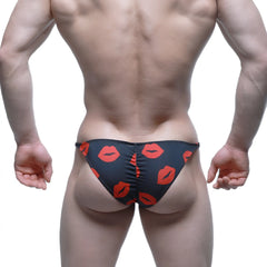 Black swim trunks by MetroMaleWear featuring a bold red lipstick print pattern for a stylish beach look