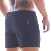 Back side of metro malewear flexible swim trunk black 4710-20 showing dark navy shorts with red and white stripe pocket