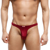 A sleek deep red mens thong from MetroMaleWear made of smooth stretchy fabric with a small white brand tag