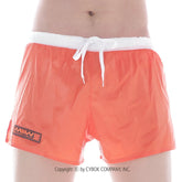 Bright orange metroMalewear iron sports swim trunks with white drawstring waistband and black logo patch on left leg
