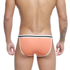 Coral-colored metroMalewear link bikini briefs with white and black striped waistband for comfortable everyday wear