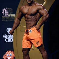 Orange MetroMaleWear MetroMuscleWear physique board short with black drawstring and shield logo on lower right leg