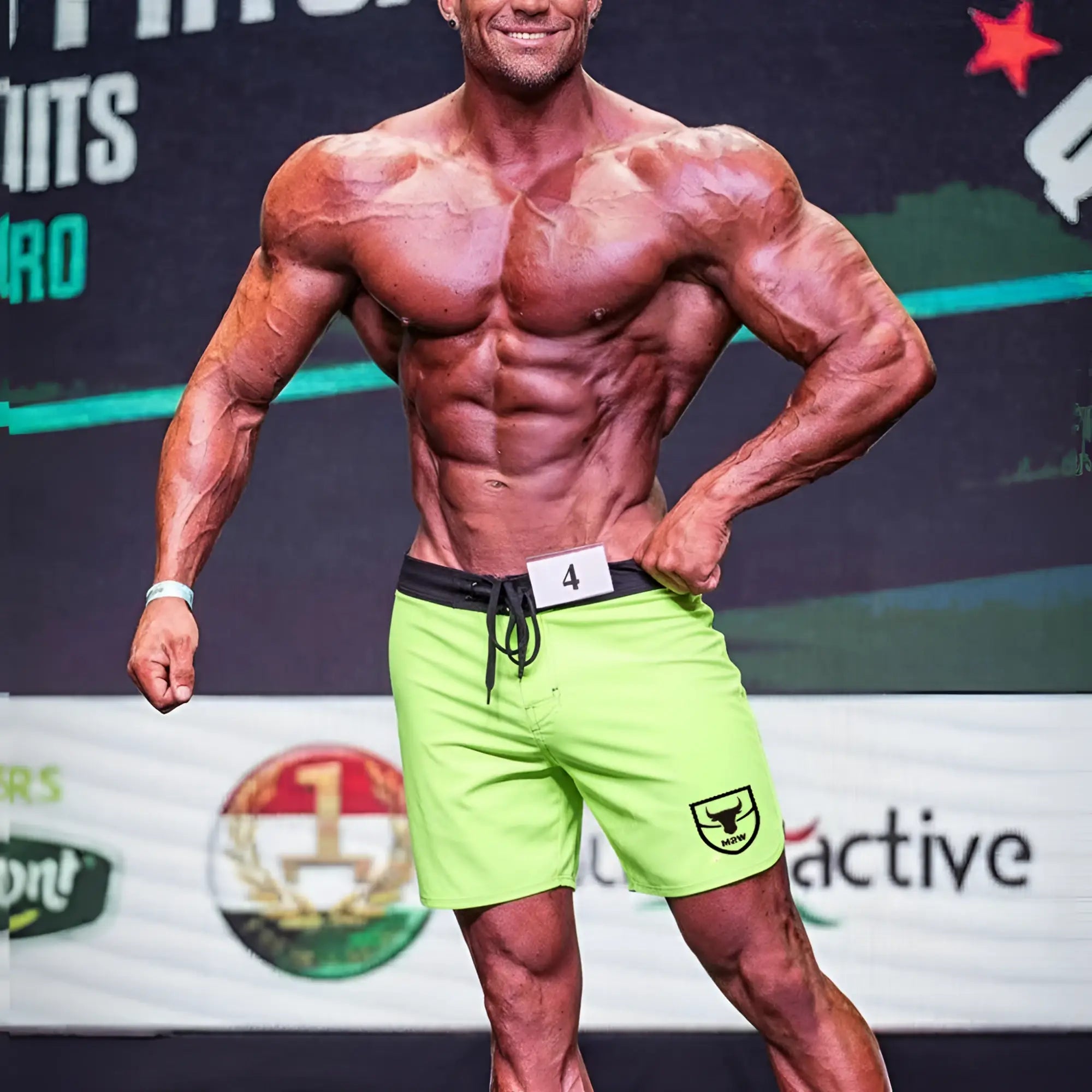 Bright neon green metro malewear physique board short with black waistband and drawstring featuring shield logo on left leg