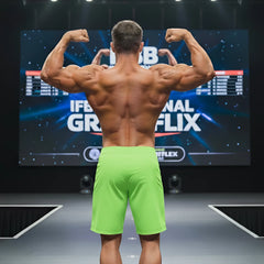 A muscular man shows the back of metroMalewear physique board short neon green 4706-07 on stage