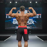 A muscular man wearing metroMalewear physique board short black with red stripe featuring a red waistband and pocket