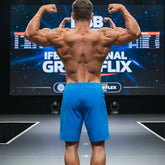 A muscular man shows the back side of metro male wear physique board short royal blue 4706-18 on stage