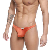 Orange satin pouch thong with small white logo tag at front by MetroMaleWear model ochre 2302-23