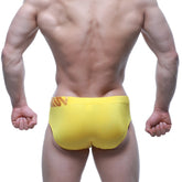 Bright yellow MetroMaleWear Rubio swim brief with subtle orange logo on waistband in athletic stretch fabric