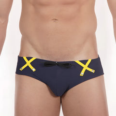 Navy blue MetroMaleWear Scottish swim brief with bold yellow x-shaped straps and black bow at the front