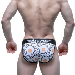 White men’s briefs with playful fried egg pattern black trim and metrcwear brand on waistband metro male wear sunny side bikini
