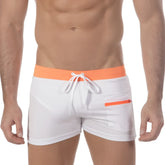 White swim trunks with a bright orange waistband and zipper pocket featuring white drawstrings from MetroMaleWear