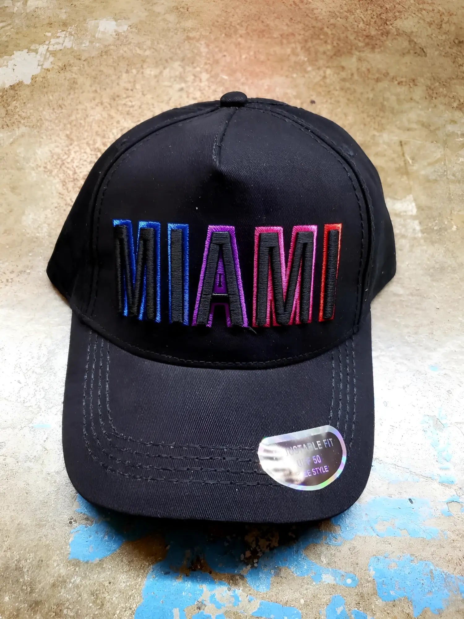 Black baseball cap with miami embroidered in gradient rainbow thread on the front perfect for casual wear