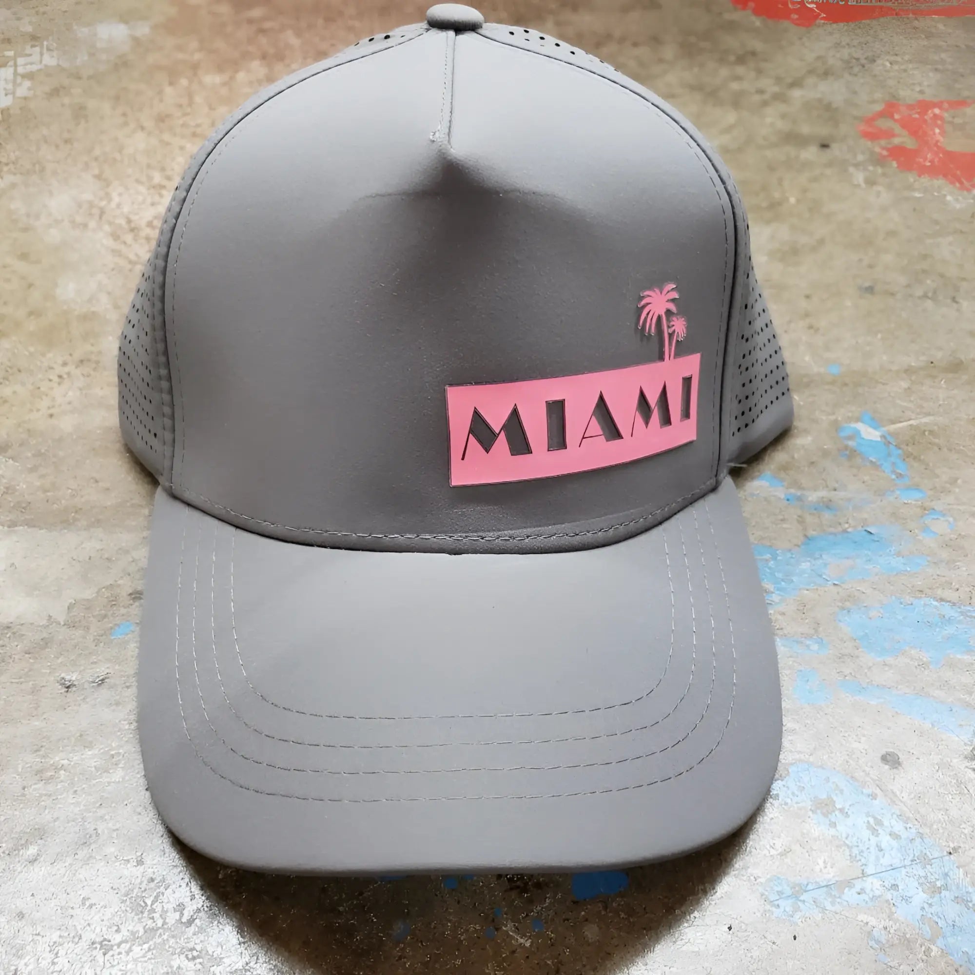 Gray miami baseball cap with pink rectangular patch featuring black lettering and palm tree design on front panel