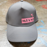 Gray miami baseball cap with pink rectangular patch featuring black lettering and palm tree design on front panel
