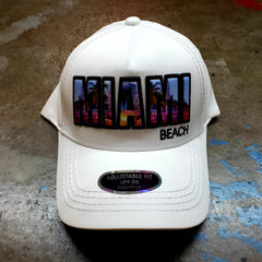 White baseball cap with vibrant colorful Miami Beach patch featuring urban skyline design and black trim