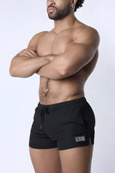 Black muzzle up athletic shorts with drawstring waistband and small rectangular logo patch on lower left leg