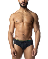 A muscular man wearing Nasty Pig black bikini swimwear with a rainbow-gradient waistband and drawstring.