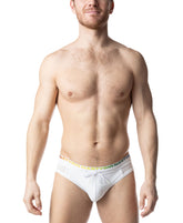 A model wears Nasty Pig white Prism Pride bikini swimwear with a multicolored logo waistband.