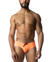 Man wearing vibrant orange Nasty Pig bikini swimwear with a black drawstring against a plain white background.