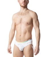 Model wearing Nasty Pig Prism Pride white bikini swimwear with a rainbow-lettered waistband and drawstring.
