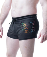 A model wearing black mesh Nasty Pig Pride trunk shorts featuring a rainbow-colored logo on the thigh.