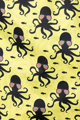 Yellow octopus print swim short fabric with repeating black octopuses wearing striped sunglasses and small fish pattern