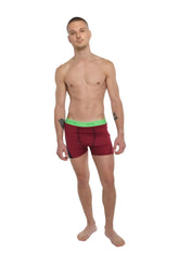 Performance yoga leggings short in brick red heather with bright green elastic waistband shown from the back