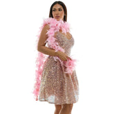 A rose gold sequined mini dress with a v-neckline and flared skirt paired with a soft pink feather boa with tinsel