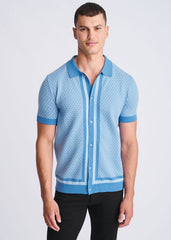 Light blue short-sleeved knit polo shirt with honeycomb texture and darker blue trim on collar placket cuffs and hem