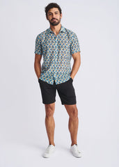 A man wearing a swirls lightweight cotton silk short sleeve shirt with blue teal and beige circular pattern