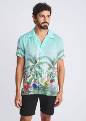 A vibrant turquoise tropical print short-sleeved modal shirt with birds and lush foliage titled tropics border print s/s modal shirt