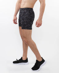 Black printed mesh stretch performance shorts with geometric leaf pattern made of lightweight fabric