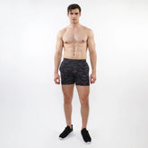 Black printed mesh stretch performance shorts with a subtle geometric leaf pattern made from lightweight fabric