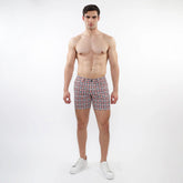 Men’s printed stretch knit swim trunks with a red blue and white geometric pattern perfect for beachwear