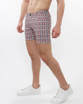 Printed stretch knit short featuring bold geometric pattern in red navy blue and white on light background
