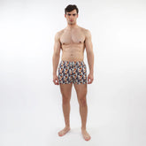 Printed swim short with mesh lining featuring vibrant orange navy blue and white tropical leaf and fruit pattern on fabric