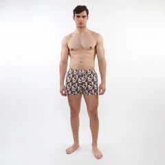 Printed swim short with mesh lining featuring vibrant orange navy blue and white tropical leaf and fruit pattern on fabric