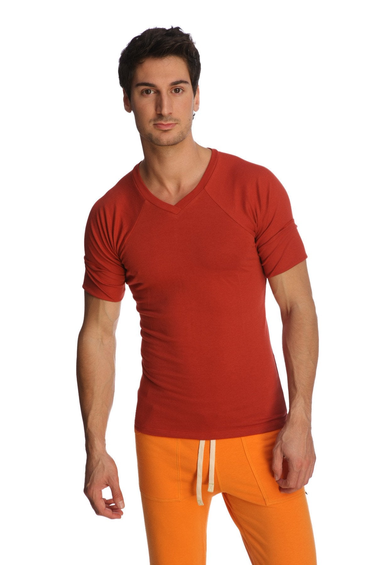 A man wearing a vibrant red raglan virtual crew neck t-shirt with subtle seam detailing and short sleeves