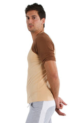 A man wearing a beige and brown two-tone raglan virtual crew neck short-sleeved t-shirt with rolled-up sleeves