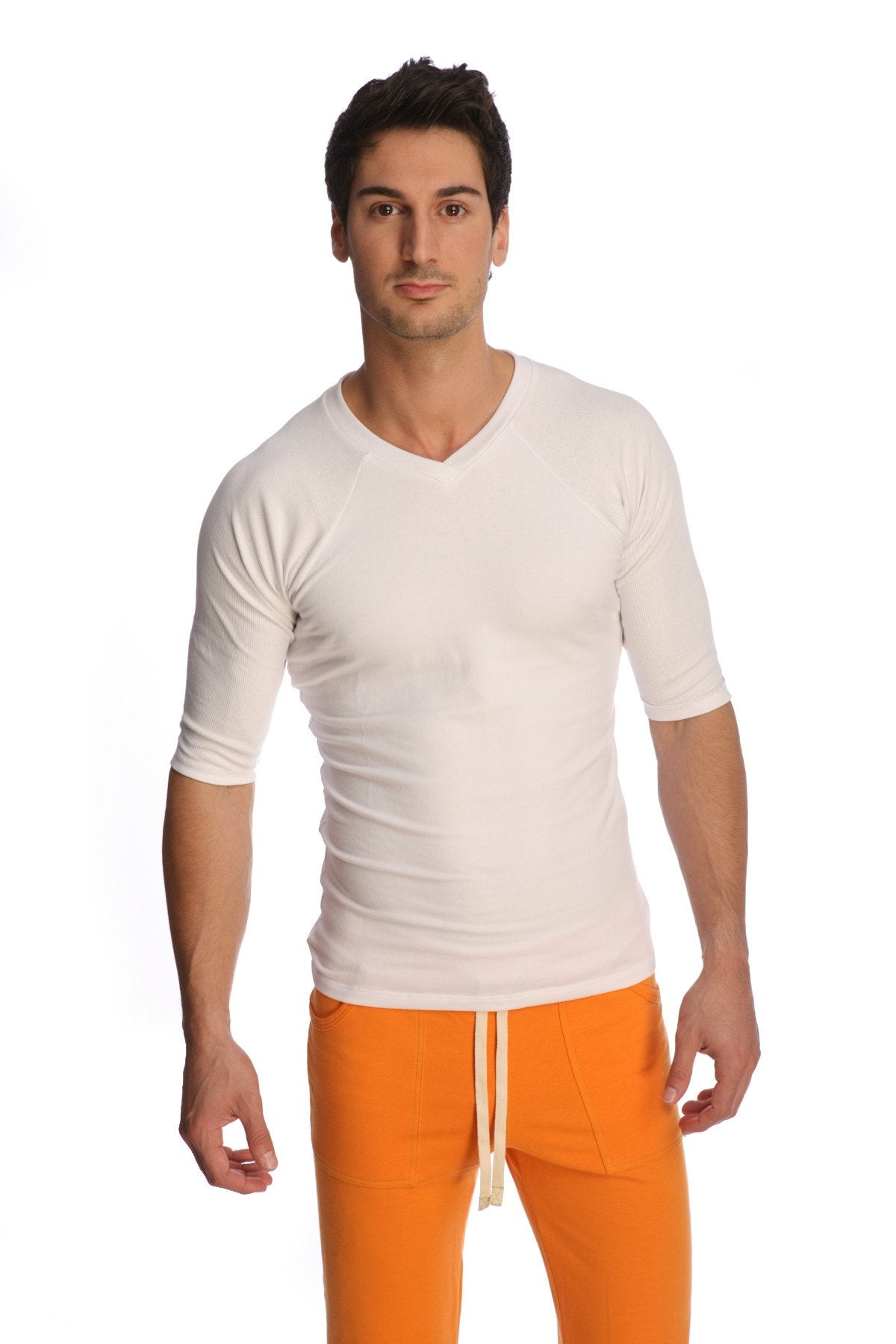 A man wearing a white raglan virtual crew neck shirt with three quarter sleeves and a v neck design